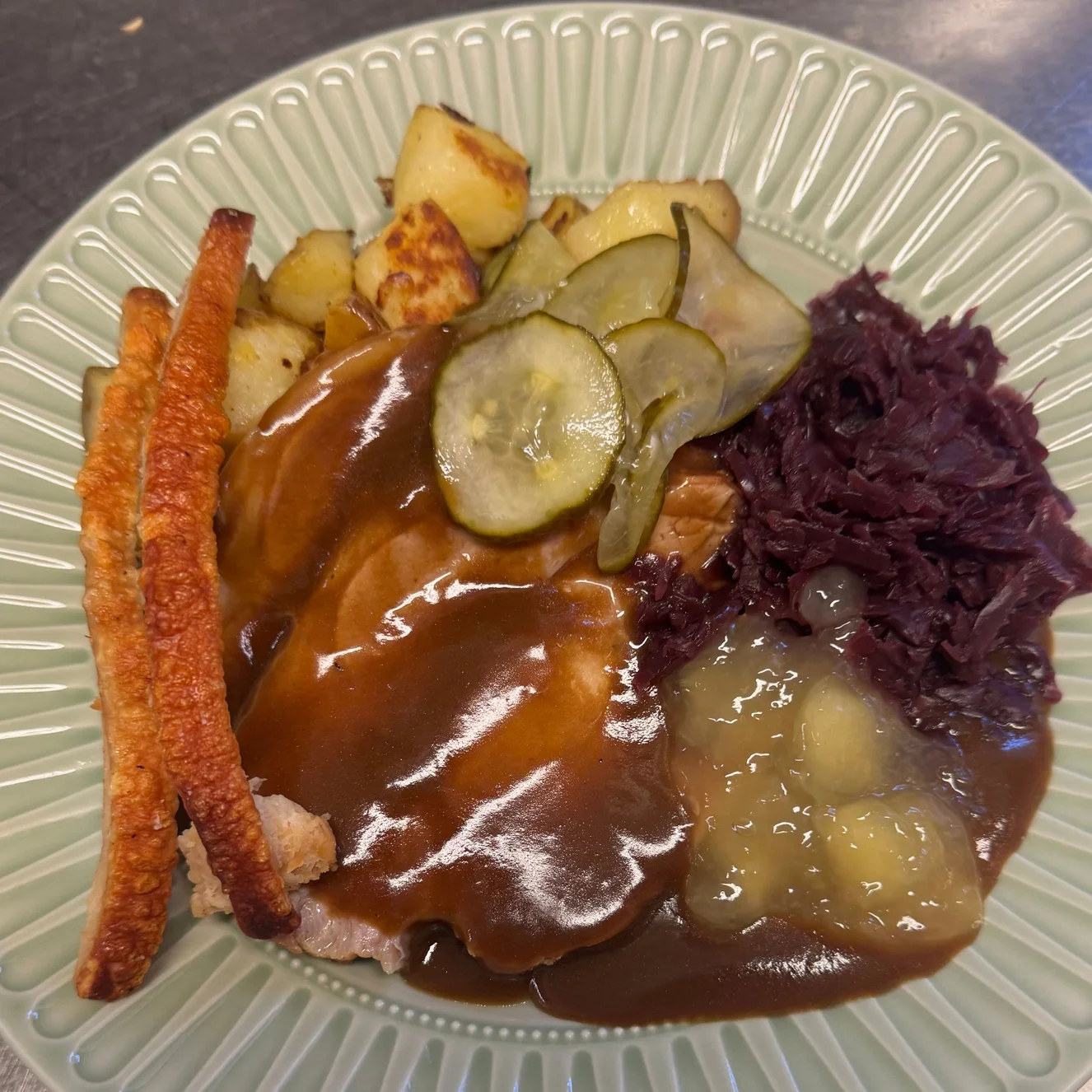 Äkta dansk flæskesteg med brunsås, rödkål, stekt potatis och inlagd gurka